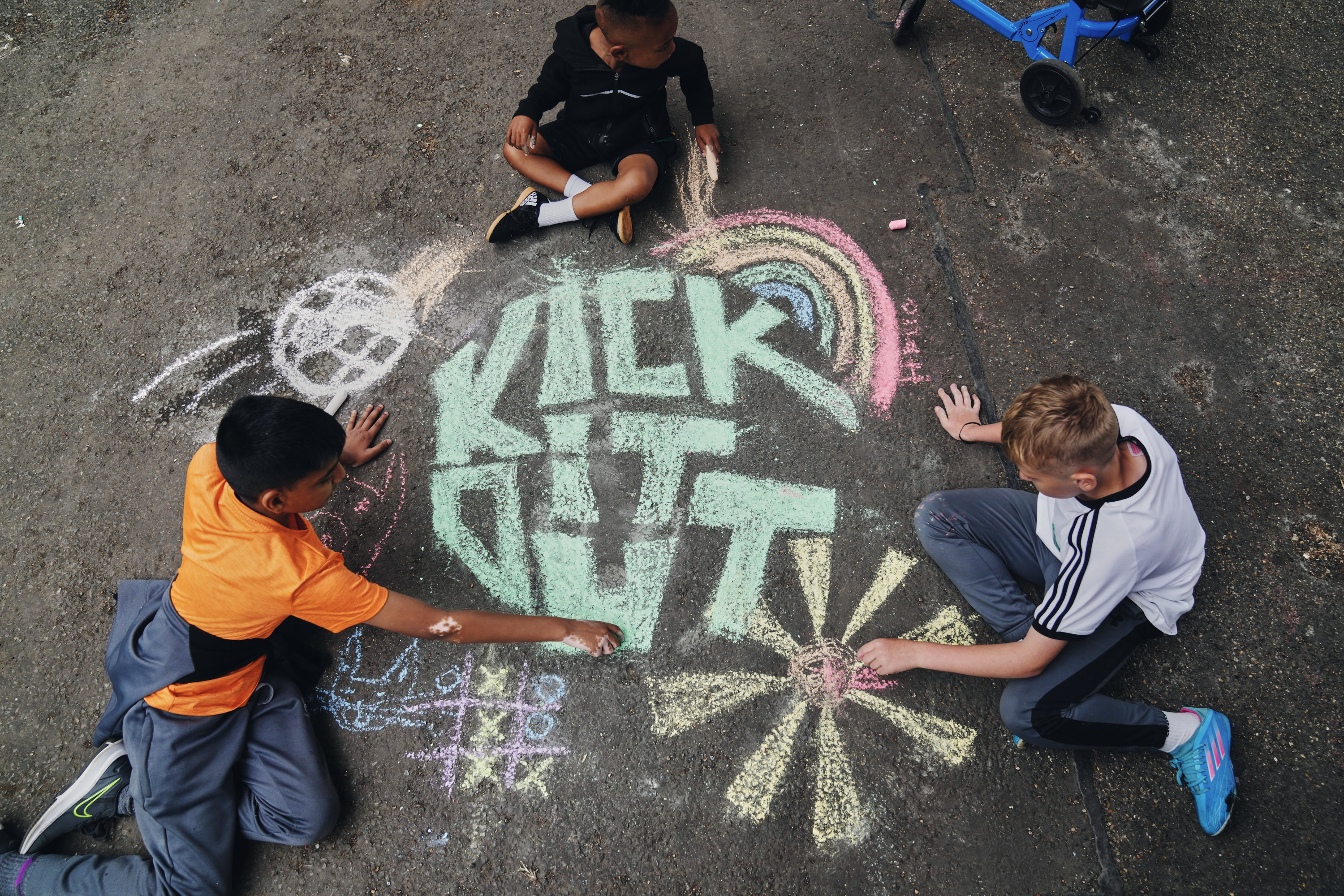 three children playing with chalk