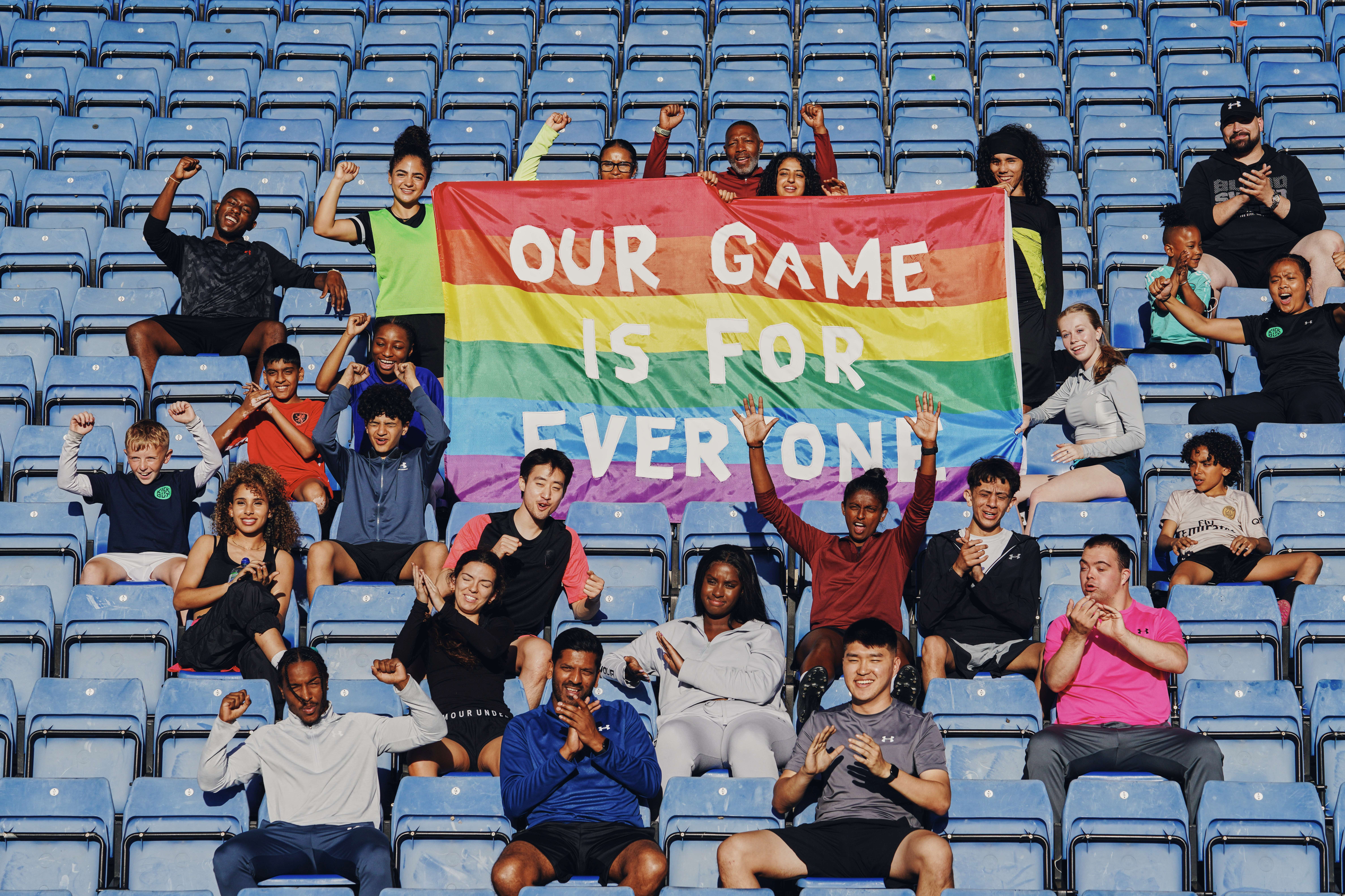 group sat around LGBTQ+ flag